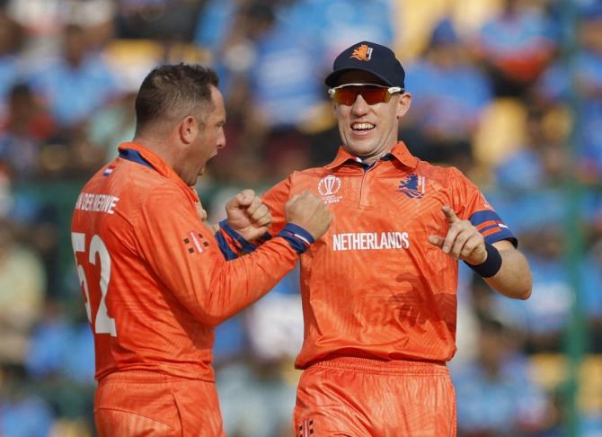 Roelof van der Merwe is congratulated by Logan van Beek after dismissing Virat Kohli