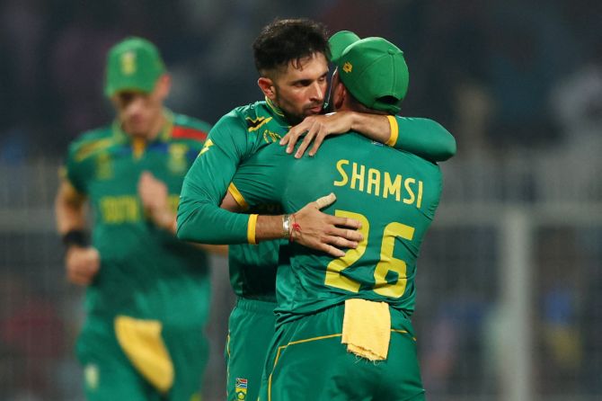South Africa's Keshav Maharaj celebrates with Tabraiz Shamsi after taking the wicket of Australia's Travis Head