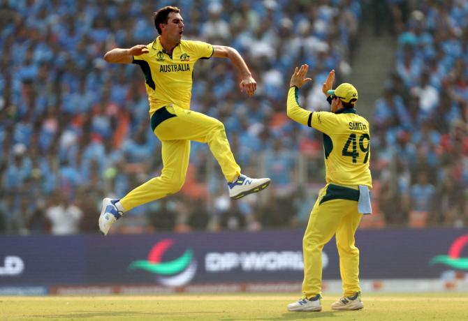 Australia's Pat Cummins celebrates with Steve Smith after taking the wicket of India's Shreyas Iyer