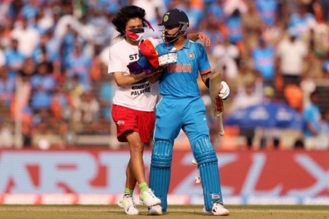Virat Kohli tries to shove aside the pitch invader during the ICC World Cup final in Ahmedabad on Sunday