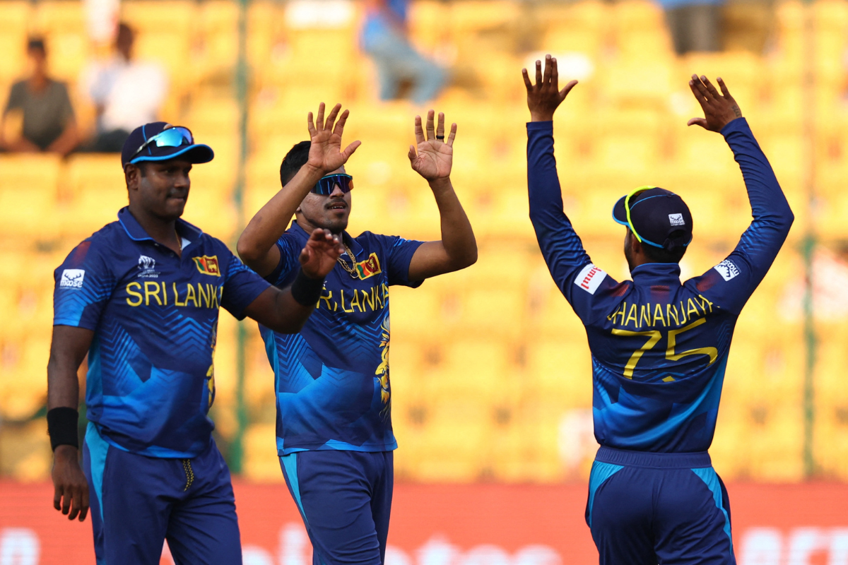 Sri Lanka's Dhananjaya de Silva, Maheesh Theekshana and Angelo Mathews celebrate the wicket of Mark Wood. 