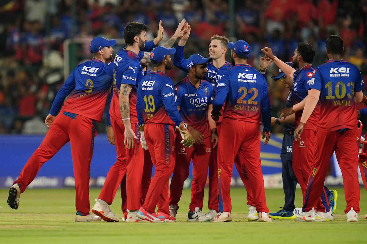 Royal Challengers Bangalore players celebrate the fall of a wicket