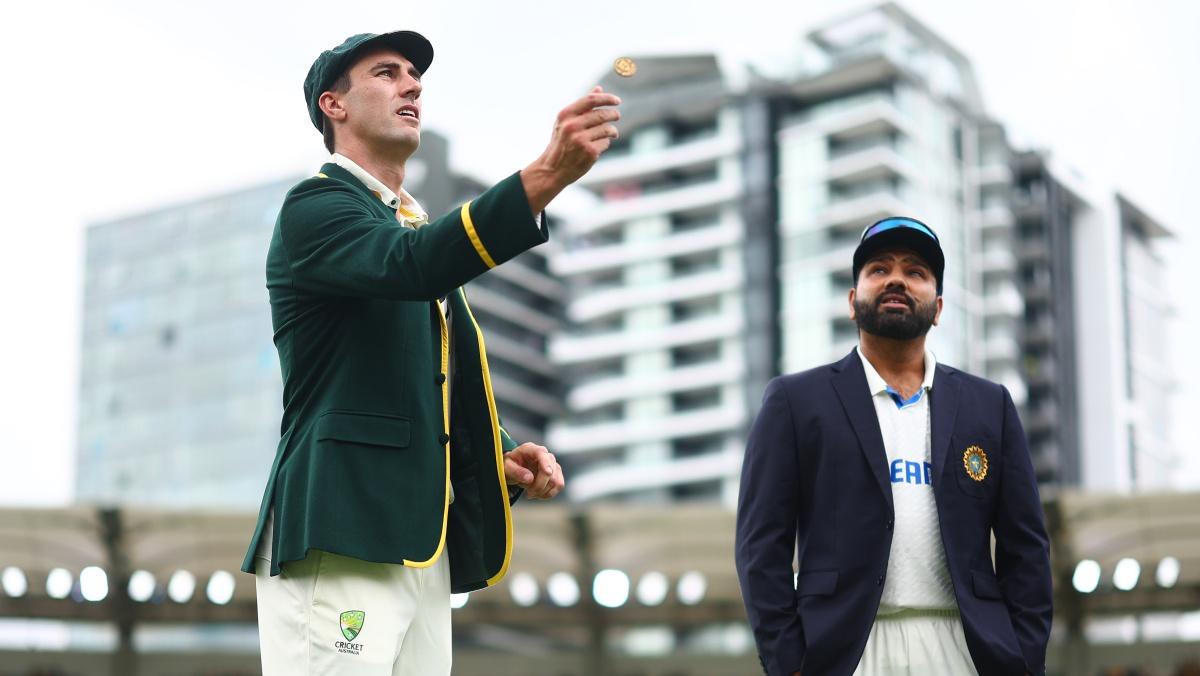 Australia's captain Pat Cummins tosses the coin as India's captain watches