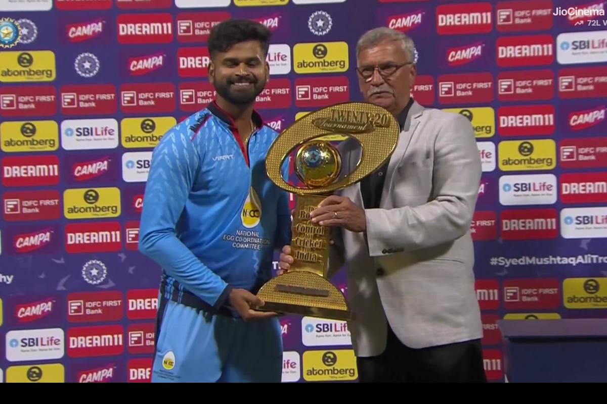 Mumbai captain Shreyas Iyer is presented with the Syed Mushtaq Ali Trophy by BCCI President Roger Binny in Bengaluru on Sunday