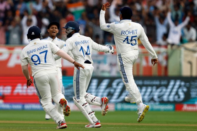 India's Rohit Sharma celebrates with Srikar Bharat and Sarfaraz Khan after taking the catch to dismiss England's Ollie Pope, off the bowling of Ravichandran Ashwin