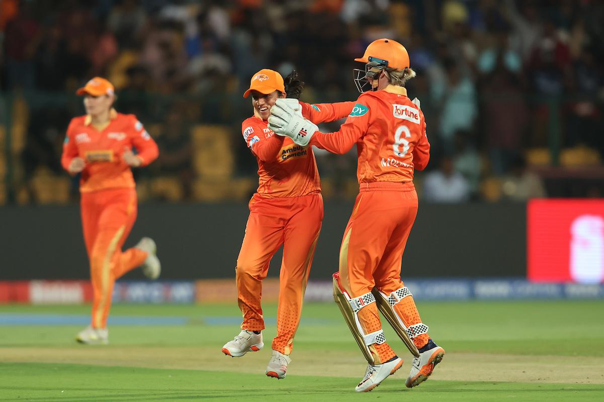 Gujarat Giants' Tanuja Kanwar and captain Beth Mooney celebrate the wicket of Hayley Matthews