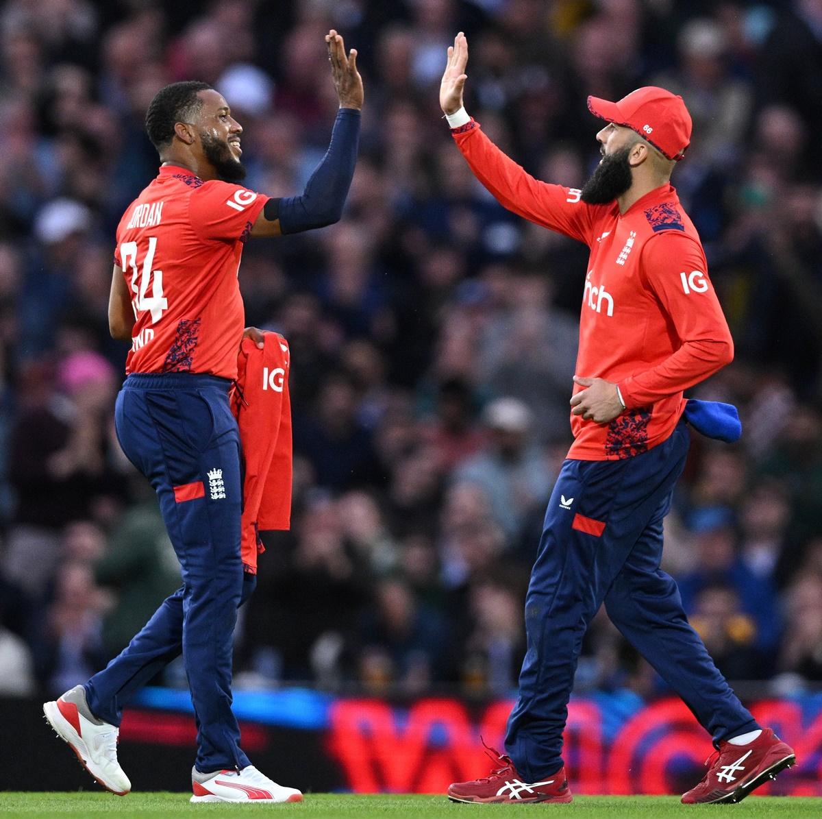 Moeen Ali celebrates with Chris Jordan after dismissing David Warner.