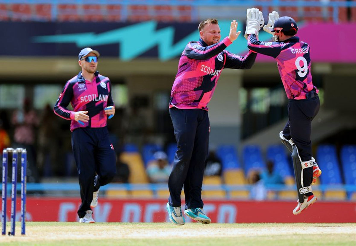 Scotland's players celebrate the fall of an Oman wicket
