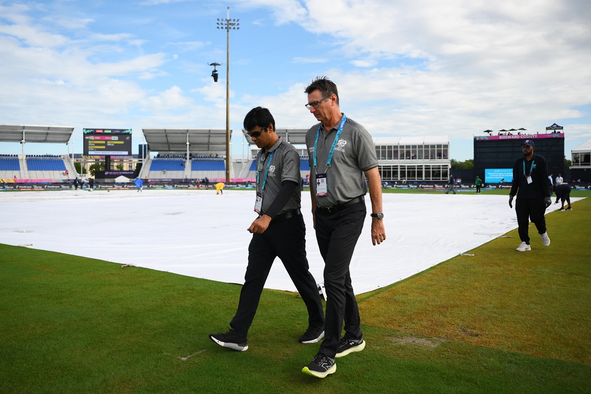 Umpires walk back after inspecting the outfield 