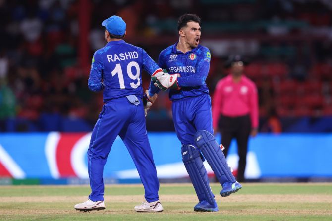 Afghanistan's Rahmanullah Gurbaz and Rashid Khan celebrate their win over Australia in their Super Eight match at the T20 World Cup, in Kingstown, St Vincent, on Sunday