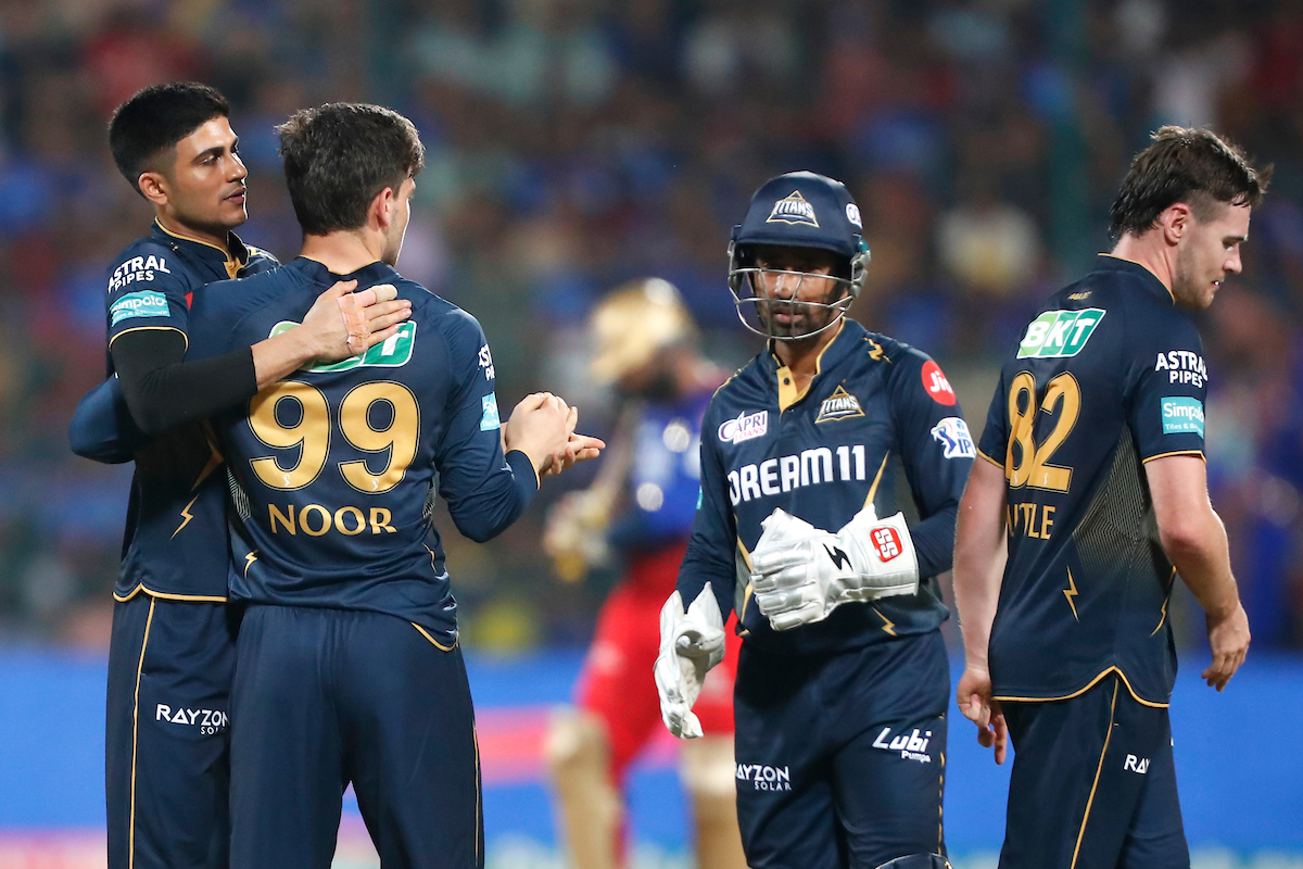 Gujarat Titans skipper Shubman Gill gives spinner Noor Ahmad a pat on the back following the dismissal of Royal Challengers Bangalore opener Virat Kohli in the IPL match in Bengaluru on Saturday.