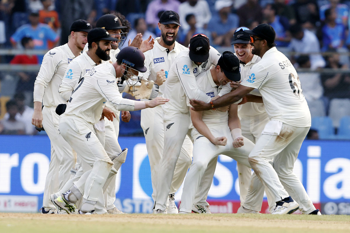 New Zealand's players celebrate the wicket of Virat Kohli.