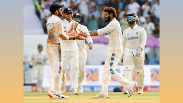 Ravindra Jadeja celebrates with teammates after taking the wicket of Ish Sodhi.