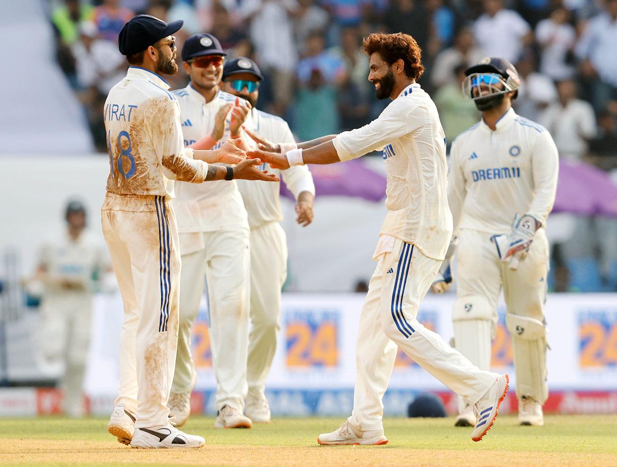 Ravindra Jadeja celebrates with teammates after taking the wicket of Ish Sodhi.