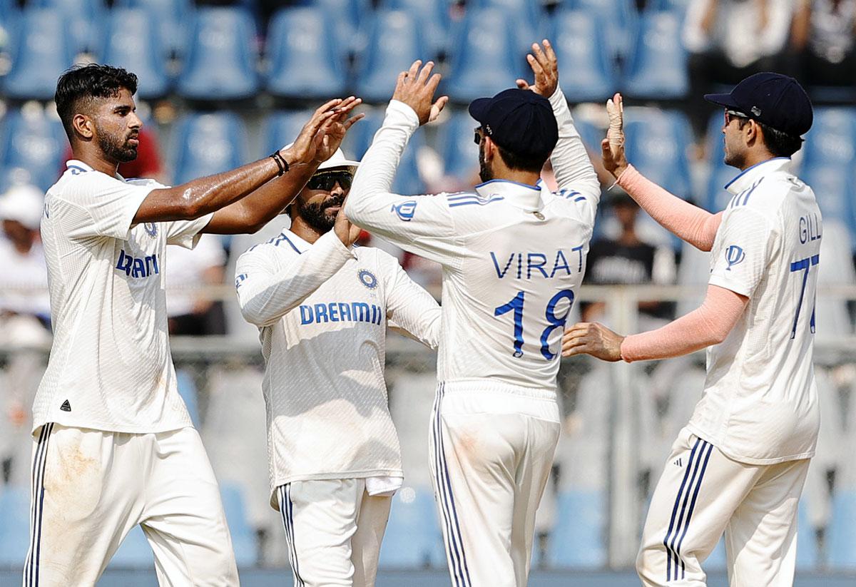 Washington Sundar celebrates with teammates after getting the wicket of Devon Conway.