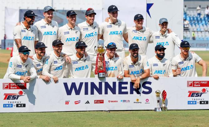 New Zealand team pose for a group picture with the trophy during a celebration after winning the third test match against India by 25 runs, at Wankhede Stadium in Mumbai