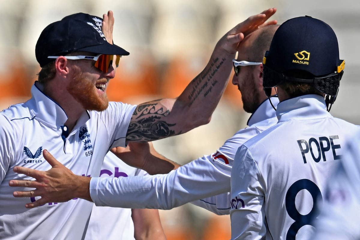 England's Jack Leach celebrates with captain Ben Stokes after taking out opener Abdullah Shafique