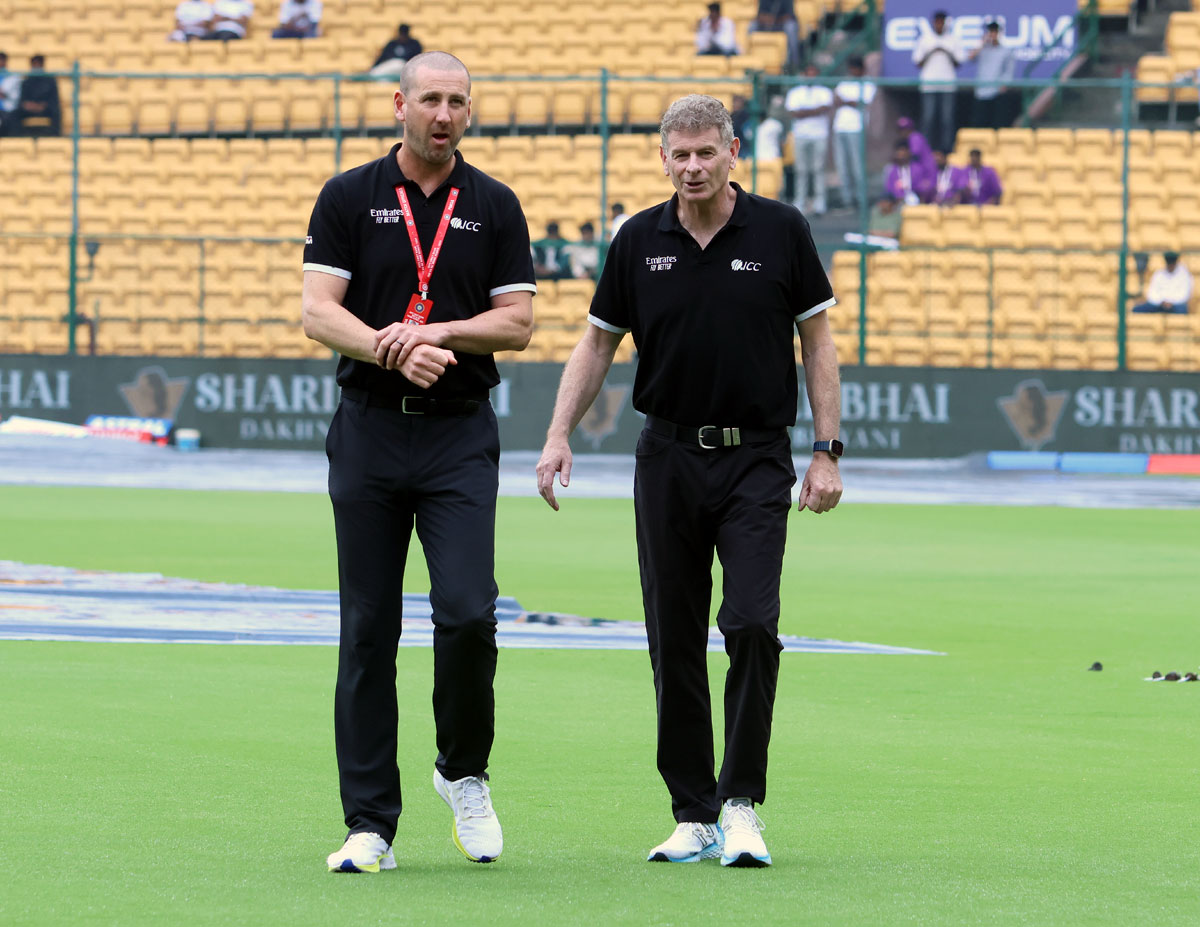 Umpires Michael Gough and Paul Reiffel inspect the outfield.