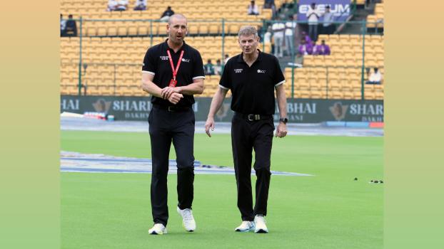 Umpires Michael Gough and Paul Reiffel inspect the outfield.
