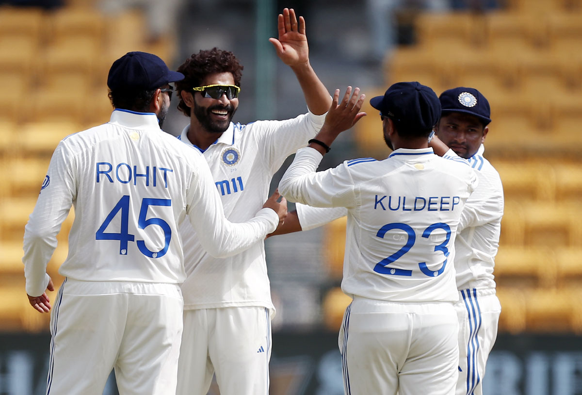 Ravindra Jadeja celebrates with teammates after taking the wicket of Glenn Phillips.