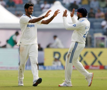 Washington Sundar celebrates with captain Rohit Sharma after taking the wicket of Rachin Ravindra