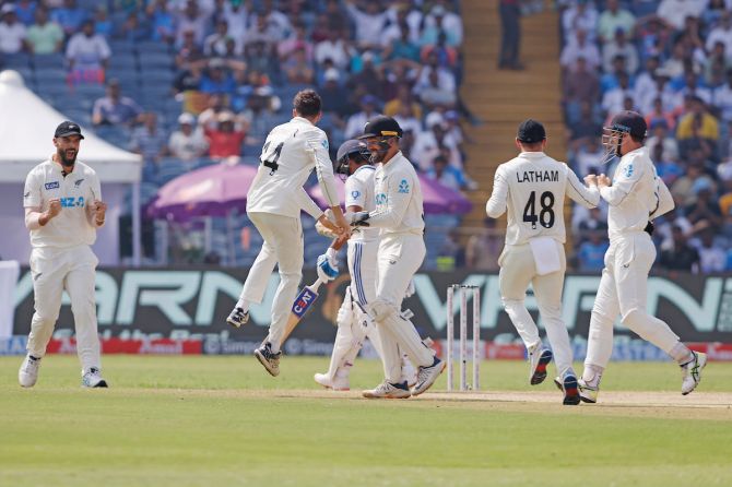 New Zealand players celebrate the wicket of Rohit Sharma