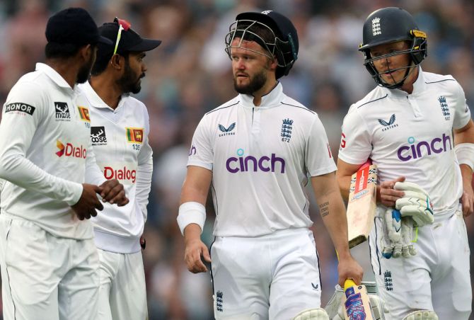 England's Ben Duckett and Ollie Pope speak to Sri Lanka's Dhananjaya de Silva and Prabath Jayasuriya 