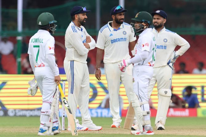  India and Bangladesh players wait for a decision before the umpires halt play due to bad light just after lunch