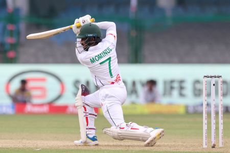 Mominul Haque drives the ball through the off-side