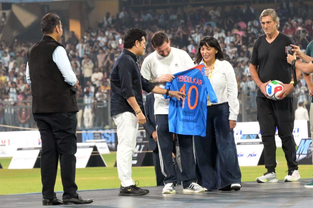 Sachin Tendulkar discusses with Lionel Messi after handing the jersey