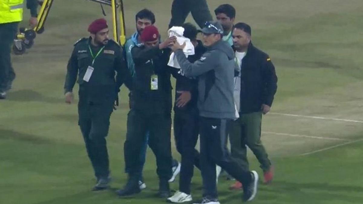 New Zealand's Rachin Ravindra is led off the field after being hit by the ball in the face during the first ODI against Pakistan in Lahore on Saturday. 