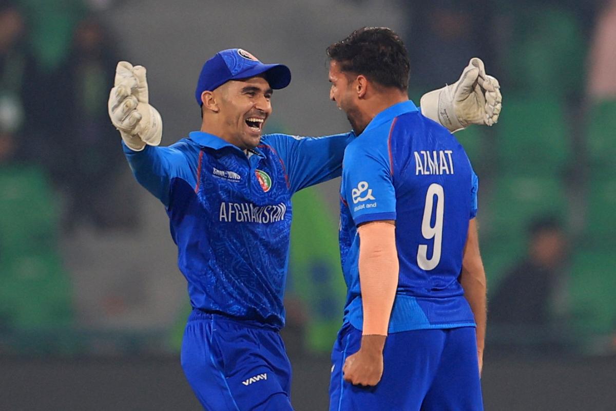 Afghanistan's Rahmanullah Gurbaz celebrates taking the wicket of England's Joe Root off the bowling of Azmatullah Omarzai