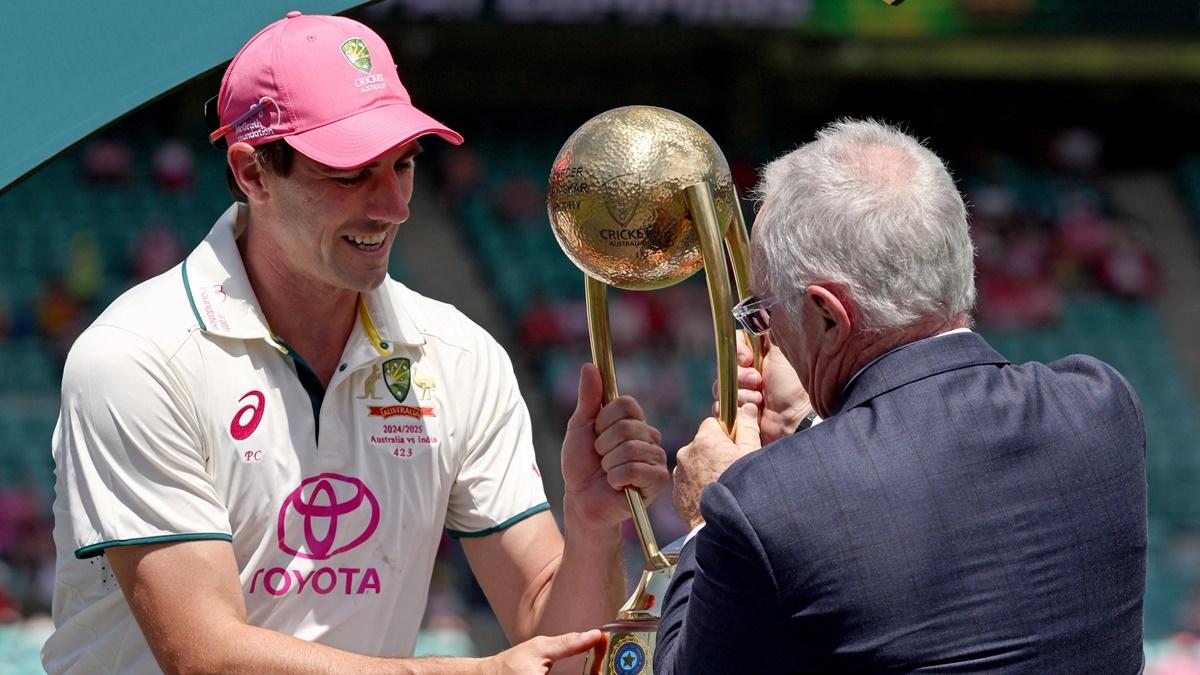 Allan Border presents the Border-Gavaskar Trophy to Pat Cummins after Australia's six-wicket victory in the fifth Test against India at the SCG