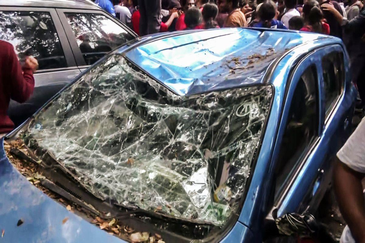 A car is damaged after Royal Challengers Banglore (RCB) fans climb over it outside the M Chinnaswamy Stadium as fans in large numbers gather to catch a glimpse of their Indian Premier League (IPL) 2025 champion team, in Bengaluru on Wednesday.