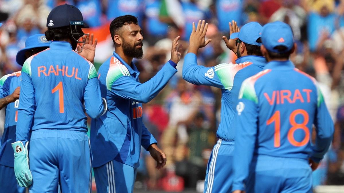 Varun Chakravarthy celebrates the fall of a wicket with his India teammates