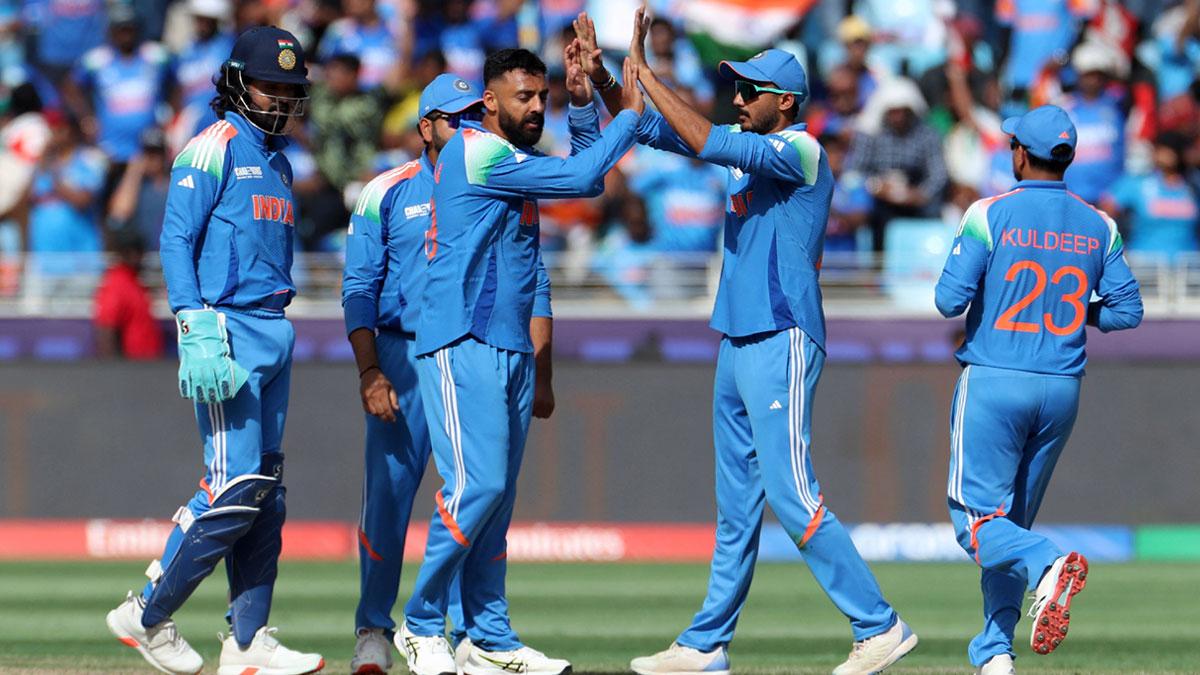 Varun Chakravarthy celebrates with teammates after taking the wicket of New Zealand's Glenn Phillips