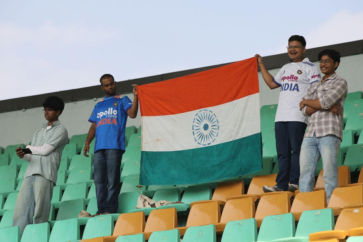 Fans raise the Indian flag during the national anthem ahead of Day 1 in the second Test between India and South Africa at the ACA stadium, in Guwahati, on Saturday, November 22, 2025.