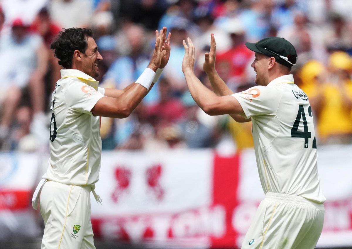 Mitchell Starc celebrates with Cameron Green after dismissing Ben Stokes.
