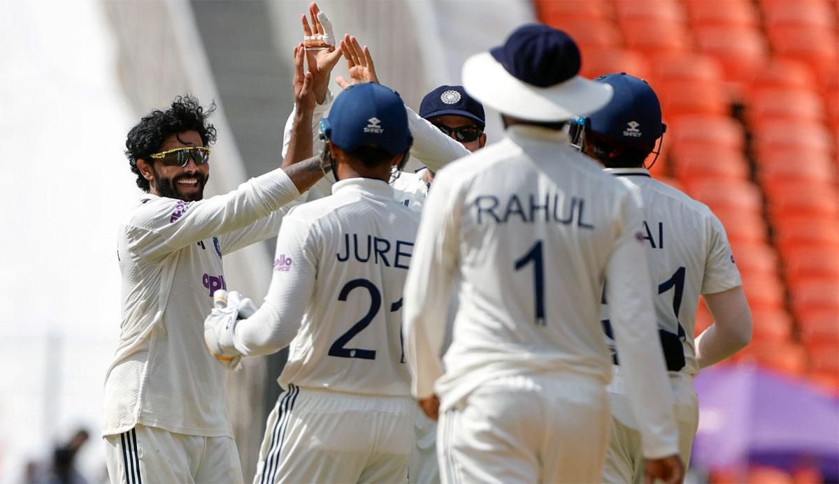 Ravindra Jadeja celebrates with team-mates after taking the wicket of John Campbell.
