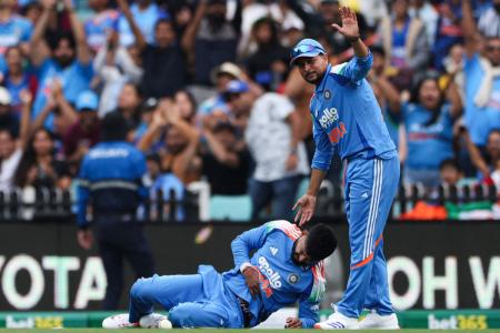 India's Shreyas Iyer reacts in pain after taking a catch to dismiss of Australia's Alex Carey as India's Kuldeep Yadav looks on during the 3rd ODI against Australia in Sydney on Saturday