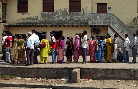 People stand in queue to cast their votes at a polling booth in Dharavi