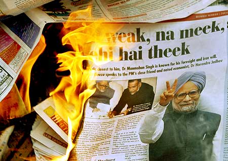 A copy of a newspaper showing photographs of PM Singh burnt by the BJP activists in Mumbai on July 23, 2008