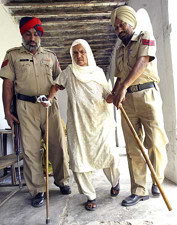 Policemen help a voter to a polling station to cast her ballot in Lopoke village on the outskirts of Amritsar on Wednesday