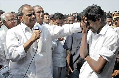 Reddy comforts a person during a visit to Mehboobnagar district