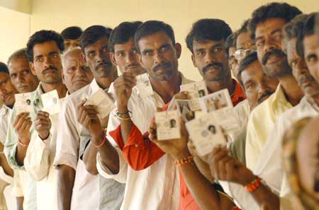 Voters show their voter identity cards before they cast their ballot