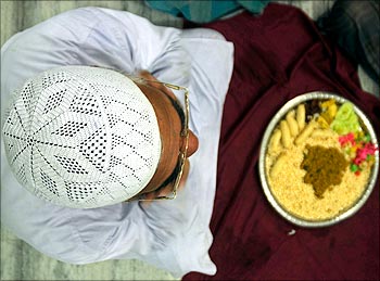 A Muslim man sits before breaking his fast on the second day of the holy month of Ramzan at a mosque in Agartala