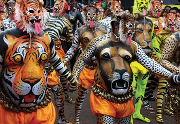 Dancers, painted to look like tigers and other large cats, perform during Kerala's harvest festival