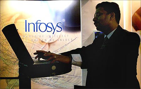 A visitor to India's largest information technology exhibition works on a laptop at a stall advertising Infosys.