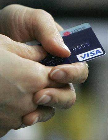 An employee of Kyobo bookstore holds a customer's credit card after swiping it to pay for purchases in Seoul.