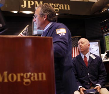 Traders work in the JP Morgan company stall on the floor of the New York Stock Exchange